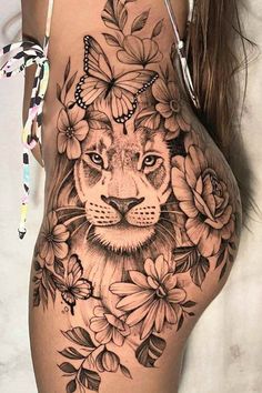 a woman's thigh with flowers and a lion on it