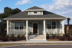 a white house with two front porches and steps leading up to the front door