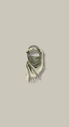 a white bracelet with tassels and beads on top of grey background, close up