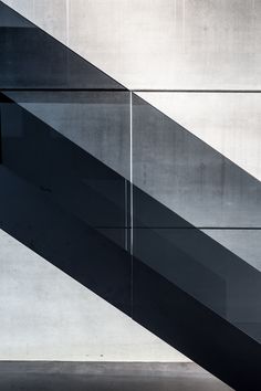 a man riding a skateboard down the side of a metal hand rail in front of a wall