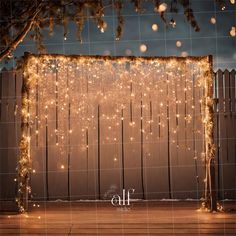 an outdoor stage decorated with fairy lights and string lights for a wedding or special event