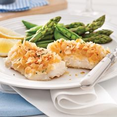 a white plate topped with fish and asparagus