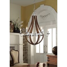 a wooden chandelier hanging from the ceiling in a room with fireplace and chairs