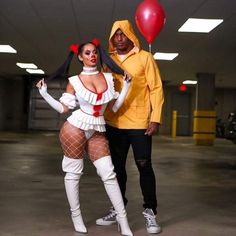 a man and woman dressed up in costume posing for a photo with a red balloon