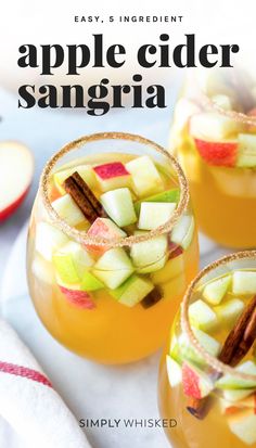 three glasses filled with apple cider sangria sitting on top of a white table