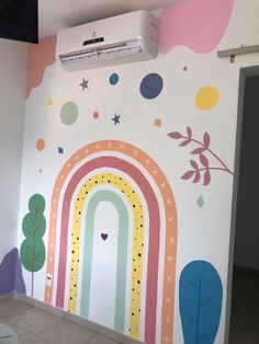 a room with a rainbow painted on the wall next to a door and ceiling fan