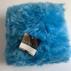 a blue furry pillow with a tag on it's front and back side that says bowrow