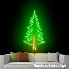 a living room with a white couch and green christmas tree wall decal on the wall