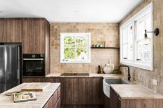 a kitchen with wooden cabinets and marble counter tops