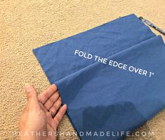 someone is holding an envelope with the words fold the edge over it on the floor