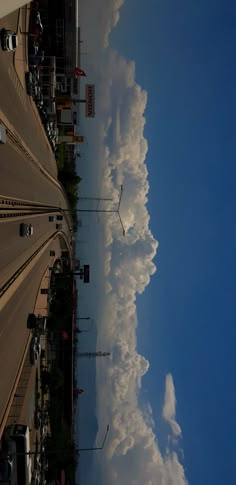 the sky is filled with clouds as seen from an over head view looking down on a street