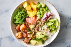 a white bowl filled with lots of different types of food on top of a table