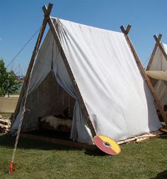 a teepee tent sitting on top of a lush green field