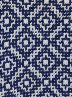 a blue and white knitted blanket with squares