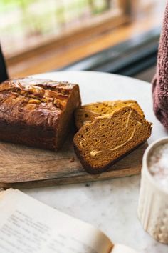 two slices of bread sitting on top of a cutting board next to an open book