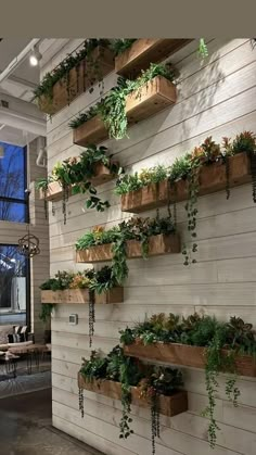 several wooden planters are hanging on the wall in front of a large window and table