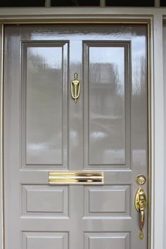 the front door is painted gray and has two handles on each side with gold trim