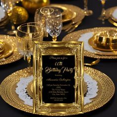 a black and gold table setting with plates, silverware and wine glasses on it