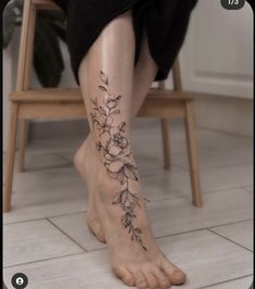 a woman's foot with flowers on it and the bottom part of her leg