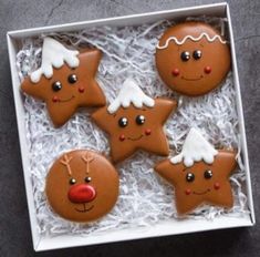 four decorated cookies in a white box