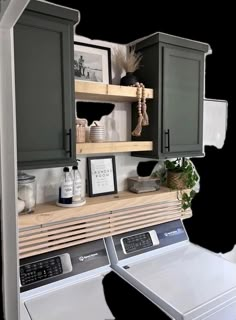 a washer and dryer sitting next to each other in front of some cabinets