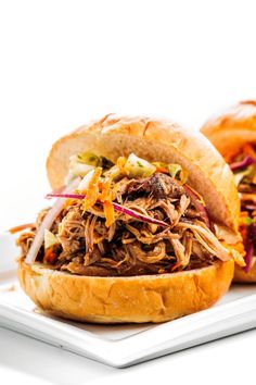 two pulled pork sandwiches on a white plate