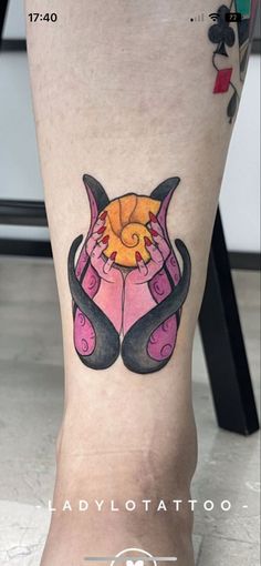 a tattoo on the leg of a woman with an orange and black cat in it