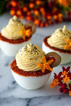 two deviled eggs with whipped cream and sprinkles in them on a marble surface