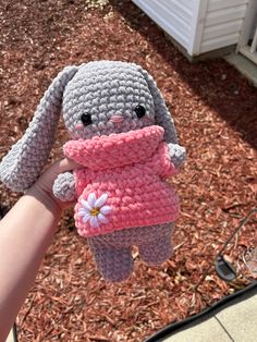 a crocheted bunny holding a pink sweater