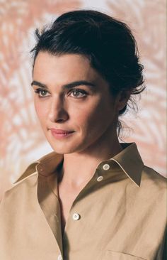 a woman wearing a tan shirt posing for a photo