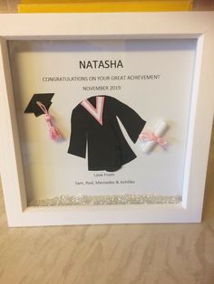 a graduation shadow box frame with an origami graduate's cap and gown