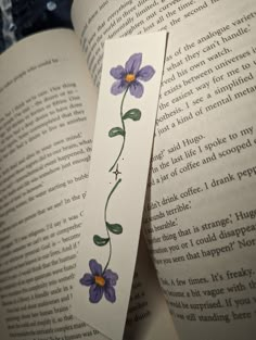 an open book with some purple flowers on it