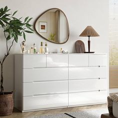 a white dresser and mirror in a room