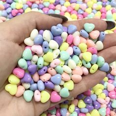 a hand holding a small pile of colorful beads