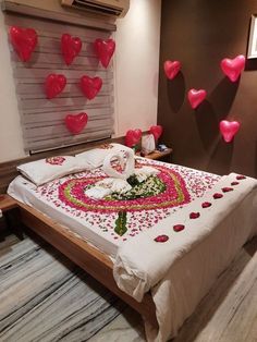 a bed room with a neatly made bed and lots of hearts on the wall