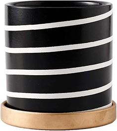 a black and white striped vase with gold trim