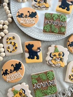 decorated cookies on a plate with decorations and beads around them, including lion cookie cutters