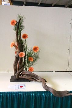 an arrangement of flowers is on display in a room with a green table cloth and white walls