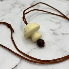 a brown cord with two white and black beads attached to it on a marble surface