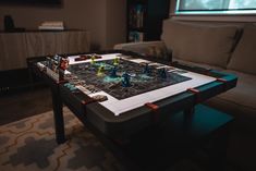 a living room with a coffee table and game set up on top of it in front of a couch