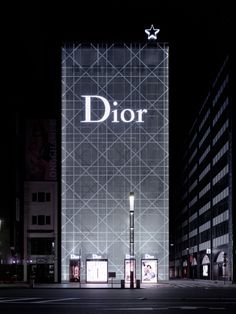 a building with the word dior lit up at night