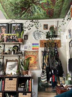 a living room filled with lots of plants and pictures on the wall next to bookshelves