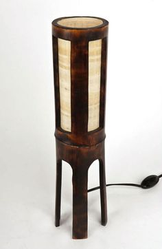 a lamp that is sitting on top of a wooden stand with a cord attached to it