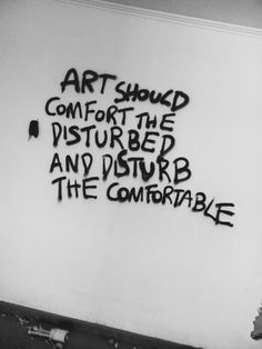 graffiti written on the side of a building reads art should comfort the disturbed and disturb the comfortableable