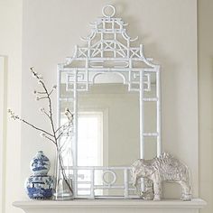 a white fireplace mantel topped with a mirror and figurine on top of it