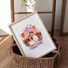 a photo frame sitting on top of a basket next to a vase with flowers in it