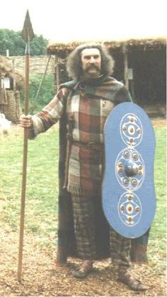 a man dressed in medieval clothing holding a spear and shield