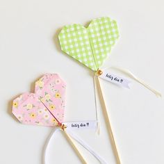 two heart shaped paper lollipops tied to clothes pins with words on them