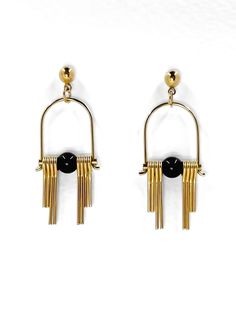 These Art Deco inspired earrings feature sleek, modern design elements, highlighting the contrast between the rich, dark hues of the black, semi precious Agate stone and the radiant golden brass. Each earring boasts a distinctive arched geometric shape inspired by the Art Deco style, lending a sense of elegance and sophistication.  The stepped cut brass fringe creates movement and shine and adds to the uniqueness and contemporary design.  Their minimalist yet bold design embodies a harmonious balance between simplicity and intricacy, making them a versatile accessory suitable for both formal occasions and everyday wear. Each earring is finished with a brass ball stud with stainless steel post. Approximate measurements- 4.5 long 1.5cms wide All Set Theory Jewellery comes with care instructi Modern Black Jewelry With Matching Earrings, Modern Black Single Earring, Modern Brass Earrings For Evening, Gold Onyx Earrings For Evening, Modern Black Enamel Jewelry, Modern Brass Linear Earrings For Formal Events, Modern Brass Linear Earrings For Formal Occasions, Modern Black Earrings For Party, Modern Gold Linear Earrings For Evening