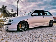 a white car parked on top of a cobblestone road